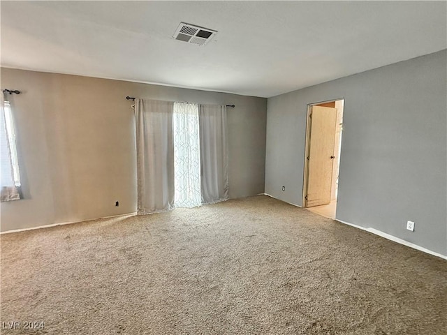 carpeted spare room featuring a healthy amount of sunlight