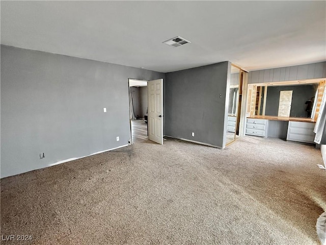 unfurnished bedroom with carpet floors and built in desk