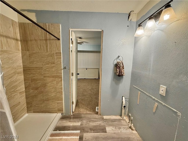 bathroom featuring hardwood / wood-style floors and tiled shower