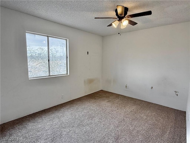 carpeted empty room with ceiling fan and a textured ceiling