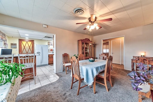 dining area featuring ceiling fan and light colored carpet