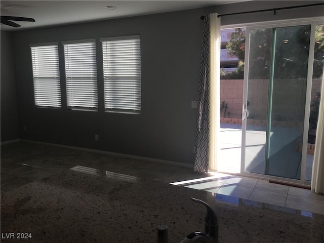 tiled spare room with ceiling fan