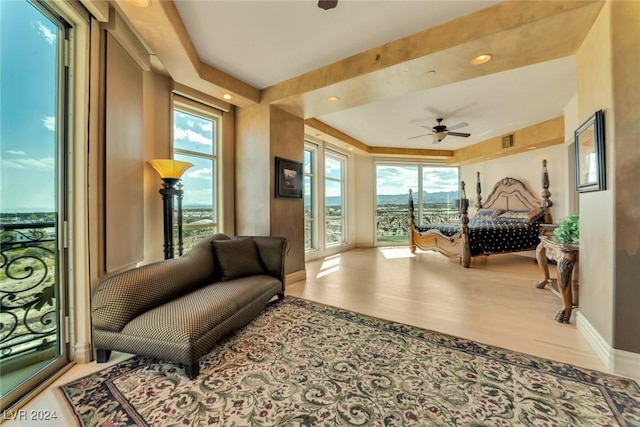 living area with ceiling fan and light hardwood / wood-style flooring