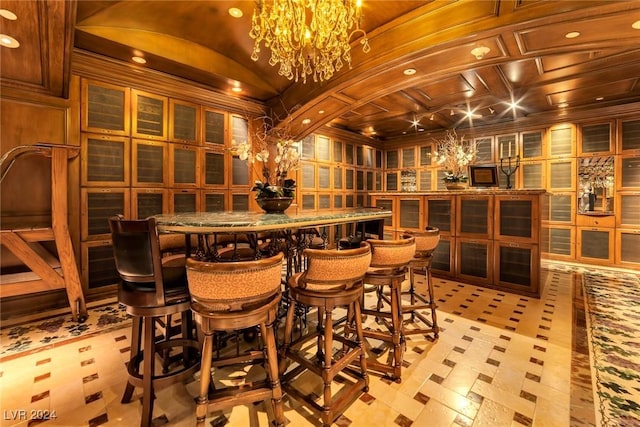 wine room featuring ornamental molding, coffered ceiling, wooden walls, a chandelier, and vaulted ceiling with beams