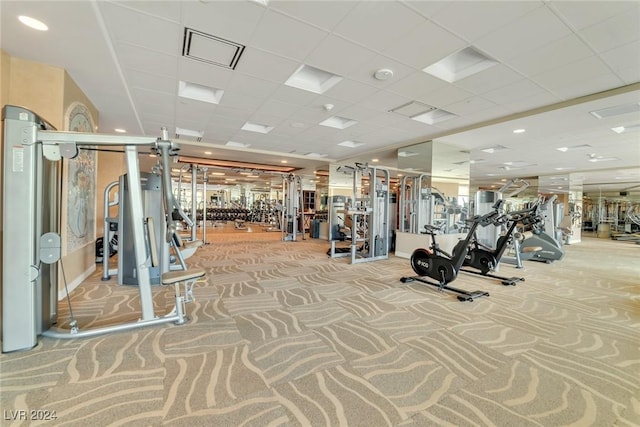 workout area featuring light carpet and a drop ceiling