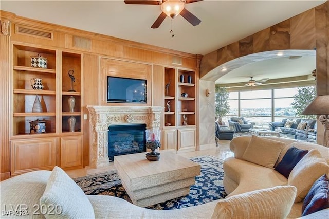 living room featuring a fireplace, wooden walls, built in features, and tile patterned flooring