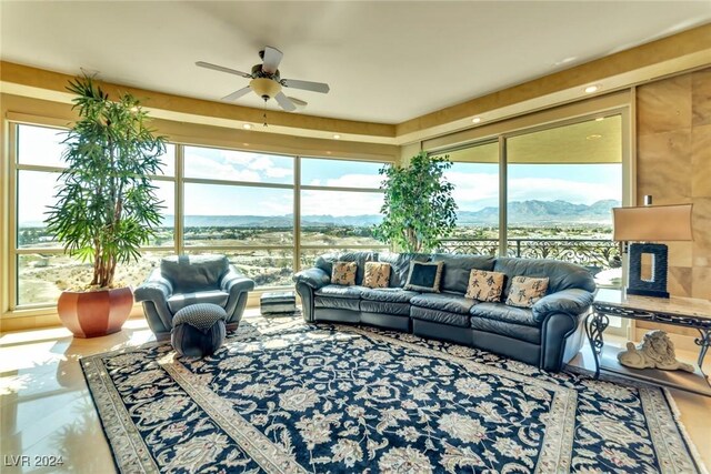 sunroom / solarium with ceiling fan and a mountain view