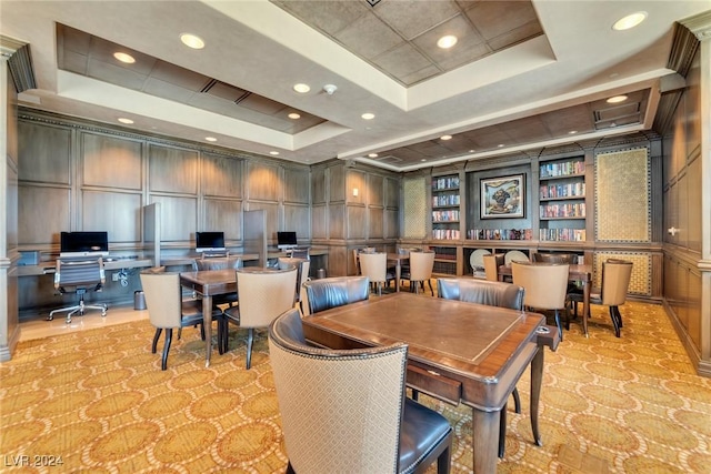 dining space featuring a tray ceiling and built in desk