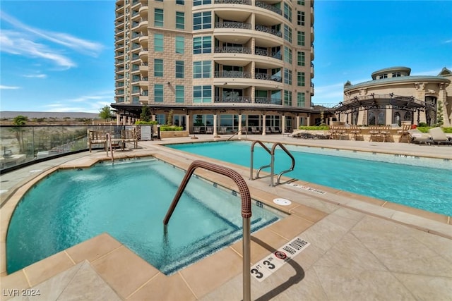 view of pool with a jacuzzi and a patio