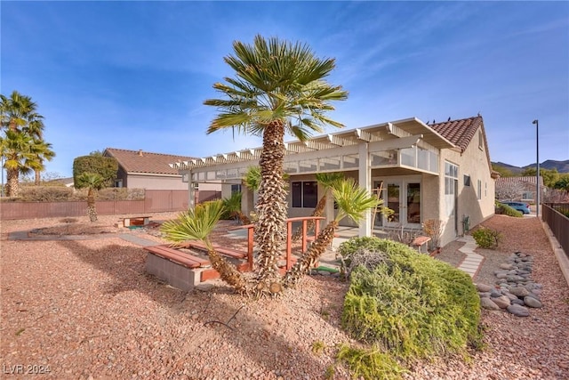 rear view of property featuring french doors and a pergola