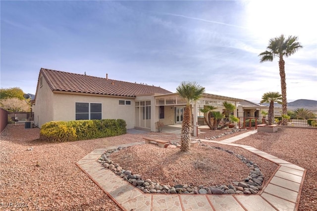 back of house with a mountain view, central air condition unit, and a patio