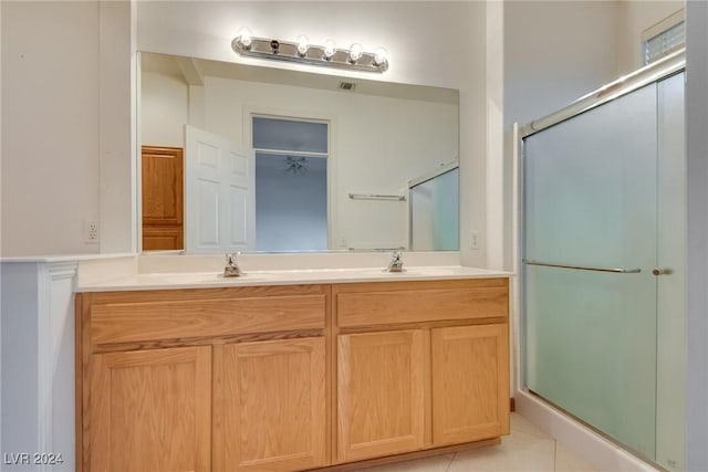 bathroom with tile patterned floors, a shower with door, and vanity