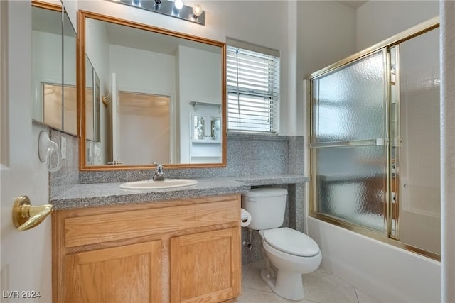 full bathroom with tile patterned flooring, vanity, toilet, and combined bath / shower with glass door