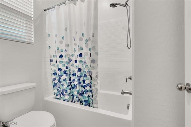 bathroom featuring shower / tub combo and toilet