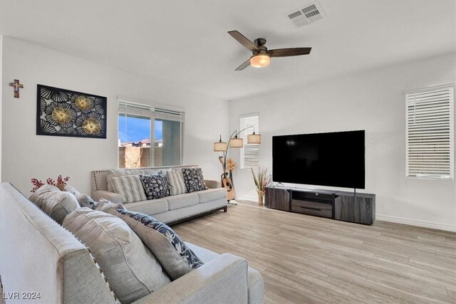 living room featuring ceiling fan and light hardwood / wood-style flooring