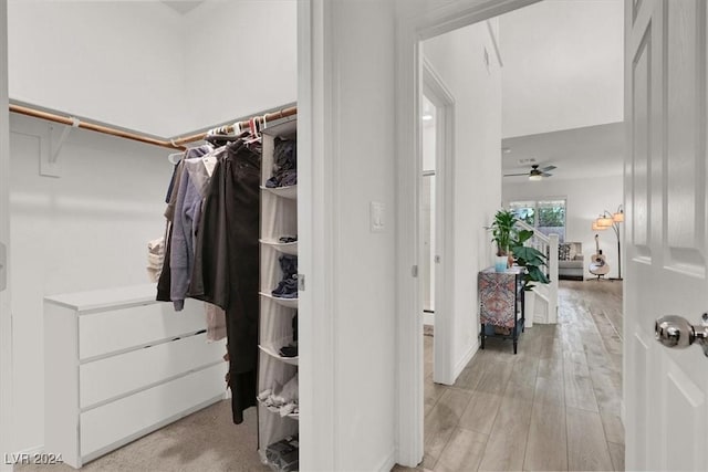 spacious closet featuring light hardwood / wood-style floors and ceiling fan