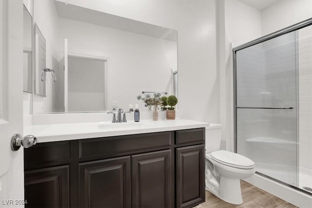 bathroom featuring hardwood / wood-style flooring, vanity, toilet, and an enclosed shower