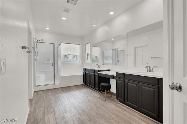 bathroom featuring hardwood / wood-style floors, vanity, and independent shower and bath