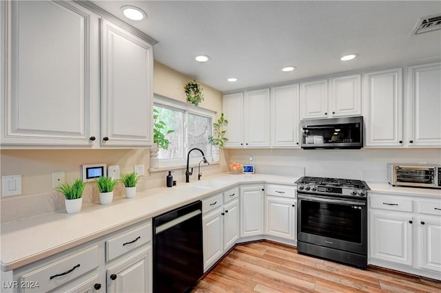 kitchen featuring white cabinetry, light hardwood / wood-style flooring, sink, and appliances with stainless steel finishes