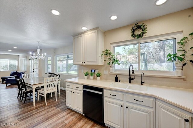 kitchen featuring white cabinetry, dishwasher, sink, a chandelier, and light wood-type flooring