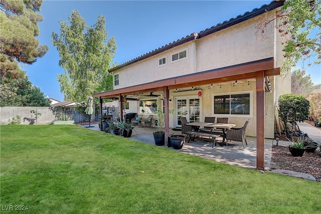 back of house featuring ceiling fan, a yard, and a patio