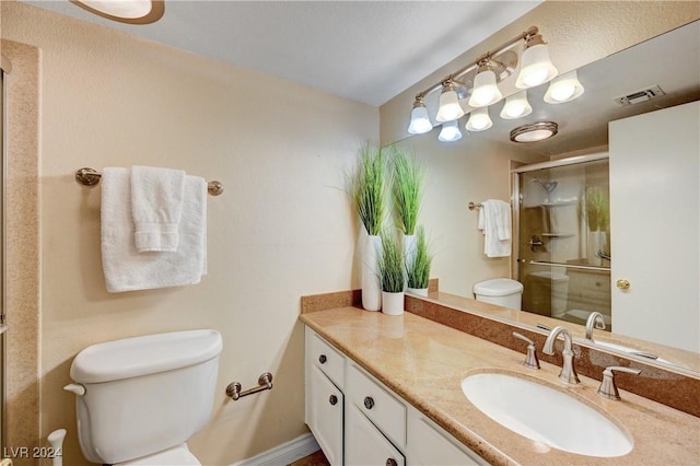 bathroom with vanity, an enclosed shower, and toilet