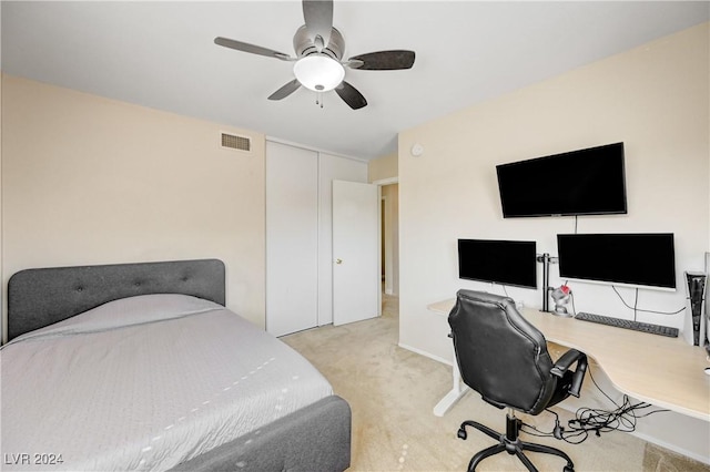 carpeted bedroom with ceiling fan and a closet