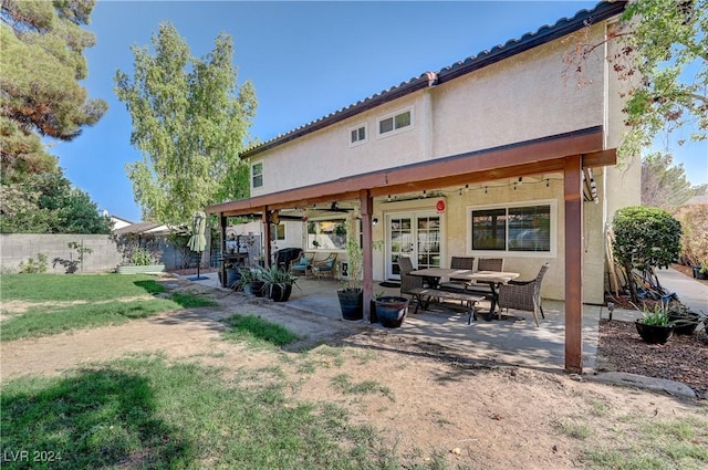 rear view of house with ceiling fan and a patio