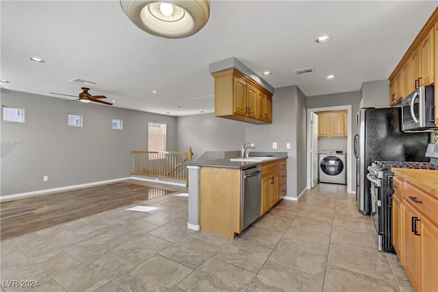 kitchen featuring appliances with stainless steel finishes, light hardwood / wood-style floors, ceiling fan, sink, and washer / clothes dryer