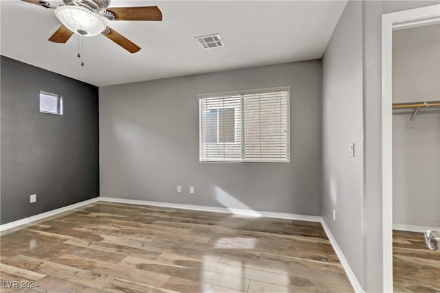 unfurnished bedroom featuring wood-type flooring, a closet, and ceiling fan