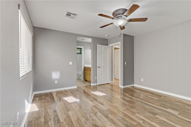 unfurnished bedroom featuring ceiling fan, connected bathroom, and light hardwood / wood-style flooring