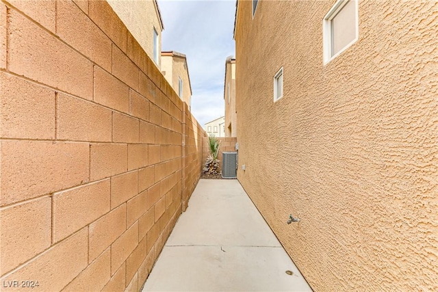 view of side of home with central air condition unit and a patio