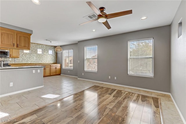 6953 Graceful Cloud, Henderson, NV 89011 - kitchen with stainless steel microwave, a ceiling fan, light wood finished floors, recessed lighting, and baseboards