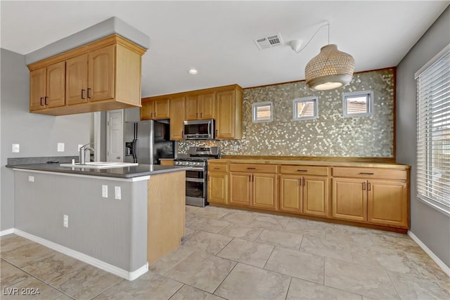 kitchen with sink, light tile patterned floors, tasteful backsplash, kitchen peninsula, and stainless steel appliances