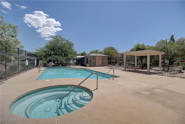 view of swimming pool with a patio area and a hot tub