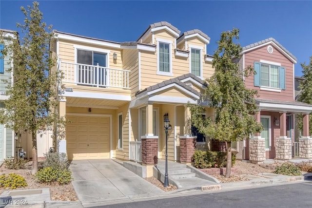 view of front of home with concrete driveway, a tile roof, a balcony, and an attached garage