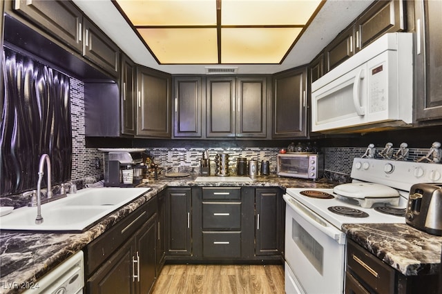 kitchen with tasteful backsplash, white appliances, sink, and light wood-type flooring