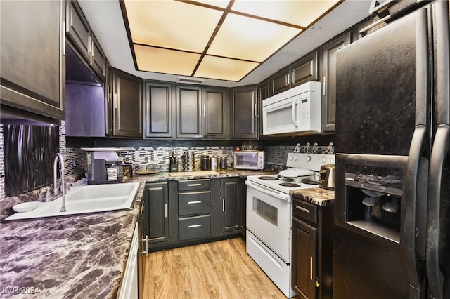 kitchen with sink, tasteful backsplash, light wood-type flooring, stone counters, and white appliances