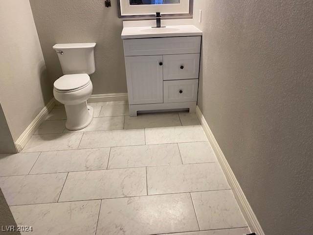 bathroom with tile patterned flooring, vanity, and toilet