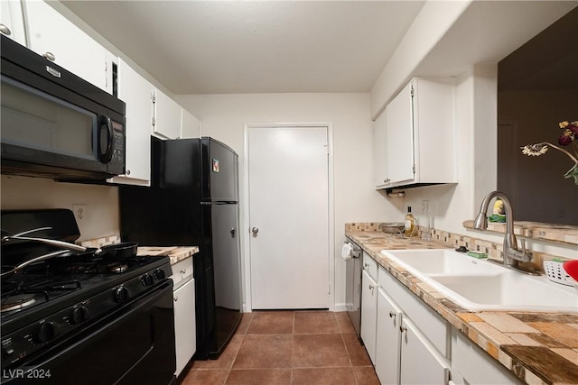 kitchen with dark tile patterned flooring, sink, white cabinetry, and black appliances