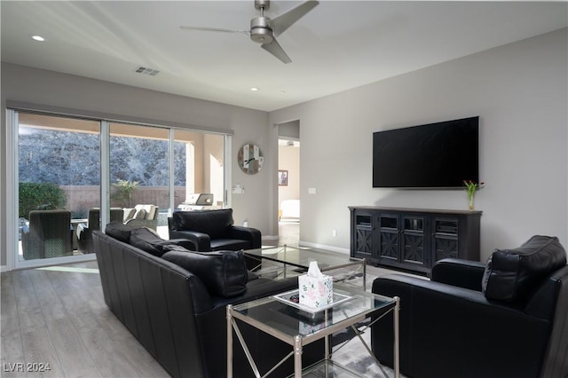 living room featuring light wood-type flooring and ceiling fan