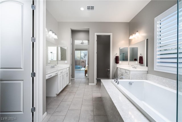 bathroom with tile patterned floors, vanity, and tiled tub