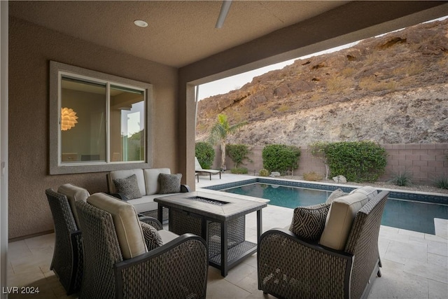 view of pool featuring a mountain view, an outdoor living space with a fire pit, and a patio area