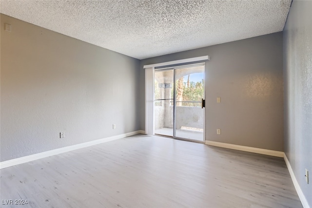 empty room featuring a textured ceiling and light hardwood / wood-style floors