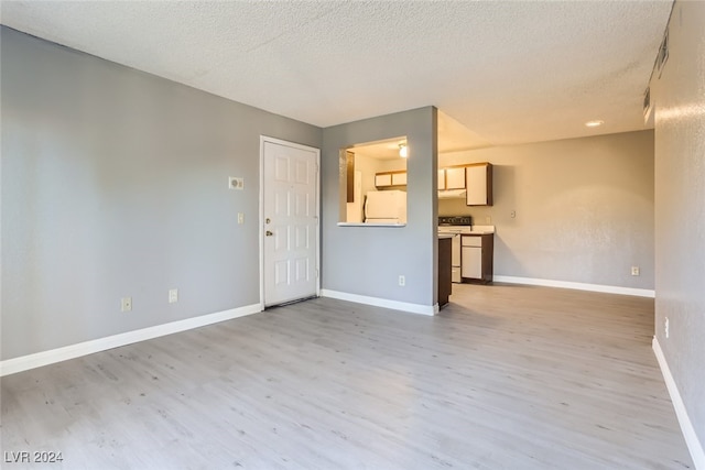 unfurnished living room featuring a textured ceiling and light hardwood / wood-style flooring