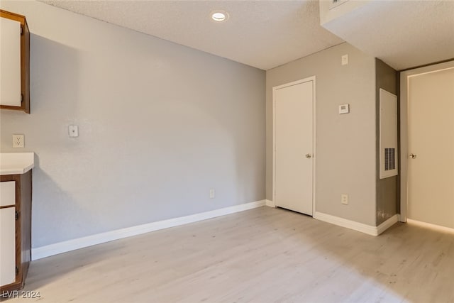 spare room featuring a textured ceiling and light wood-type flooring