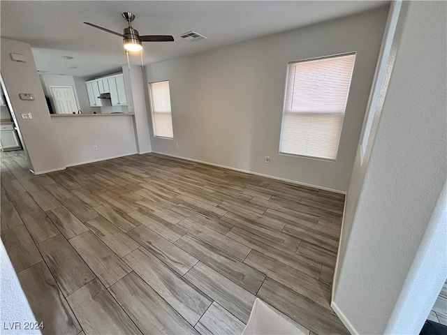 unfurnished living room with light hardwood / wood-style flooring, ceiling fan, and a healthy amount of sunlight