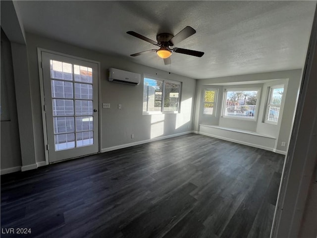 interior space with a wall unit AC, ceiling fan, dark hardwood / wood-style flooring, and a textured ceiling