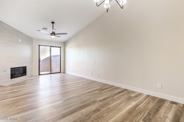 unfurnished living room featuring a large fireplace, light hardwood / wood-style flooring, and lofted ceiling