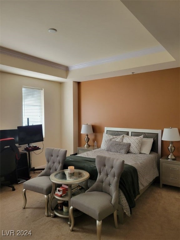 carpeted bedroom featuring ornamental molding and a tray ceiling